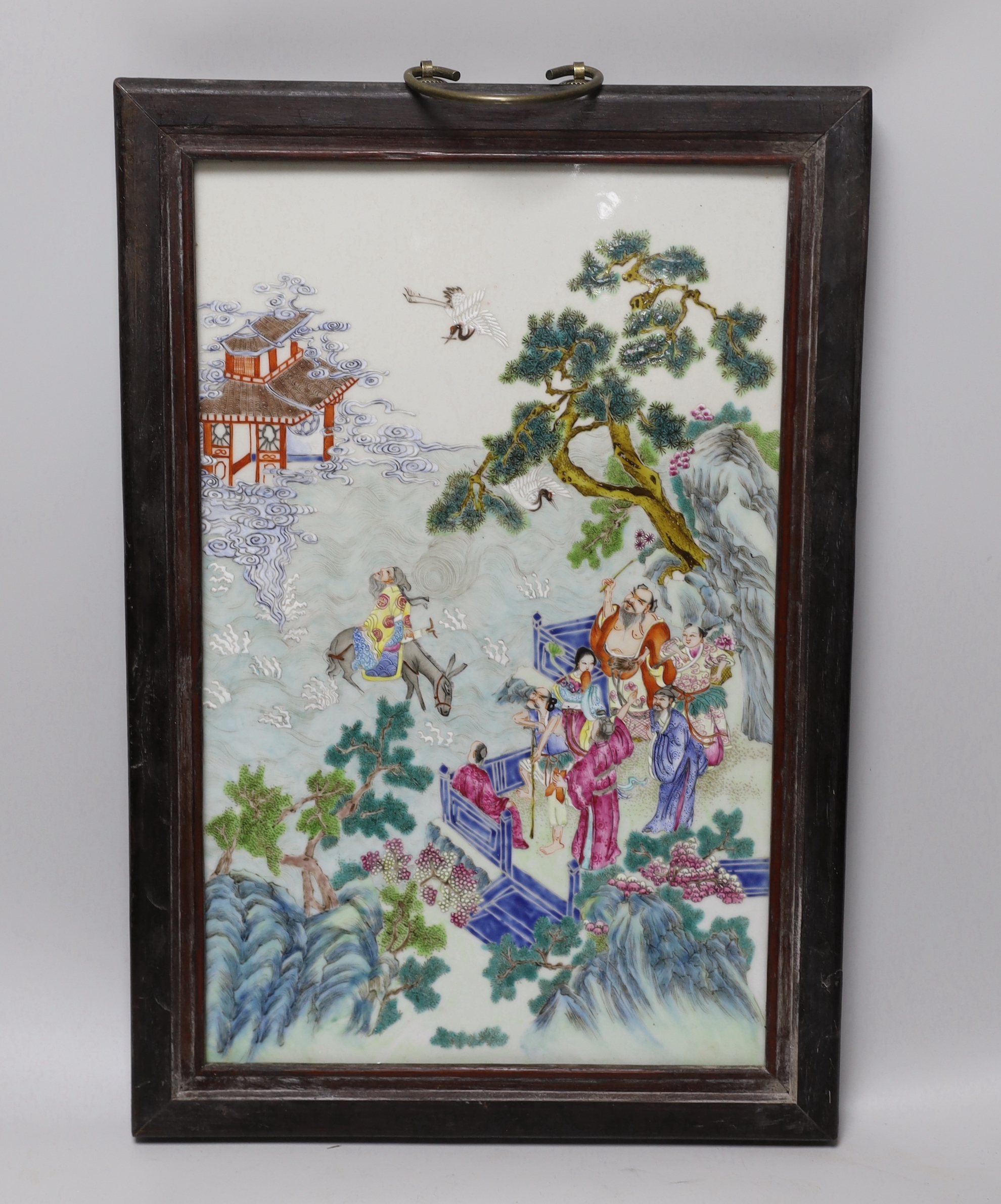 A Chinese enamelled porcelain plaque, decorated with immortals and pagodas in a landscape, framed, overall 47cm x 32cm